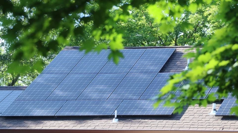 Ouvrier en bâtiment installant un panneau d'isolation thermique extérieure sur façade de maison en construction