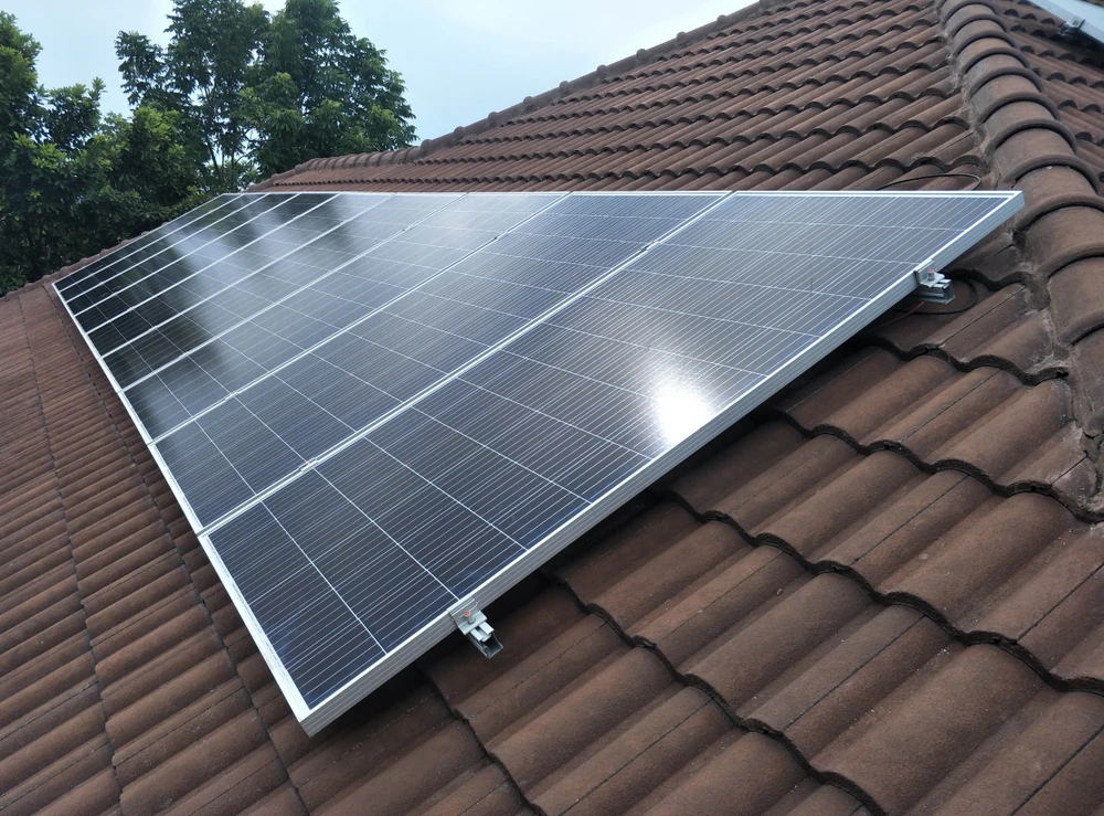 Scène extérieure montrant une installation de panneaux photovoltaïques sur toiture résidentielle